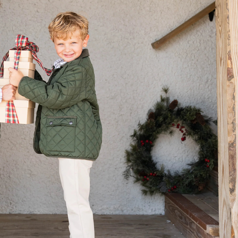 Smiling boy modeling Par Performance Pants paired with barn jacket, showcasing stylish, durable, and adjustable pants for active kids.