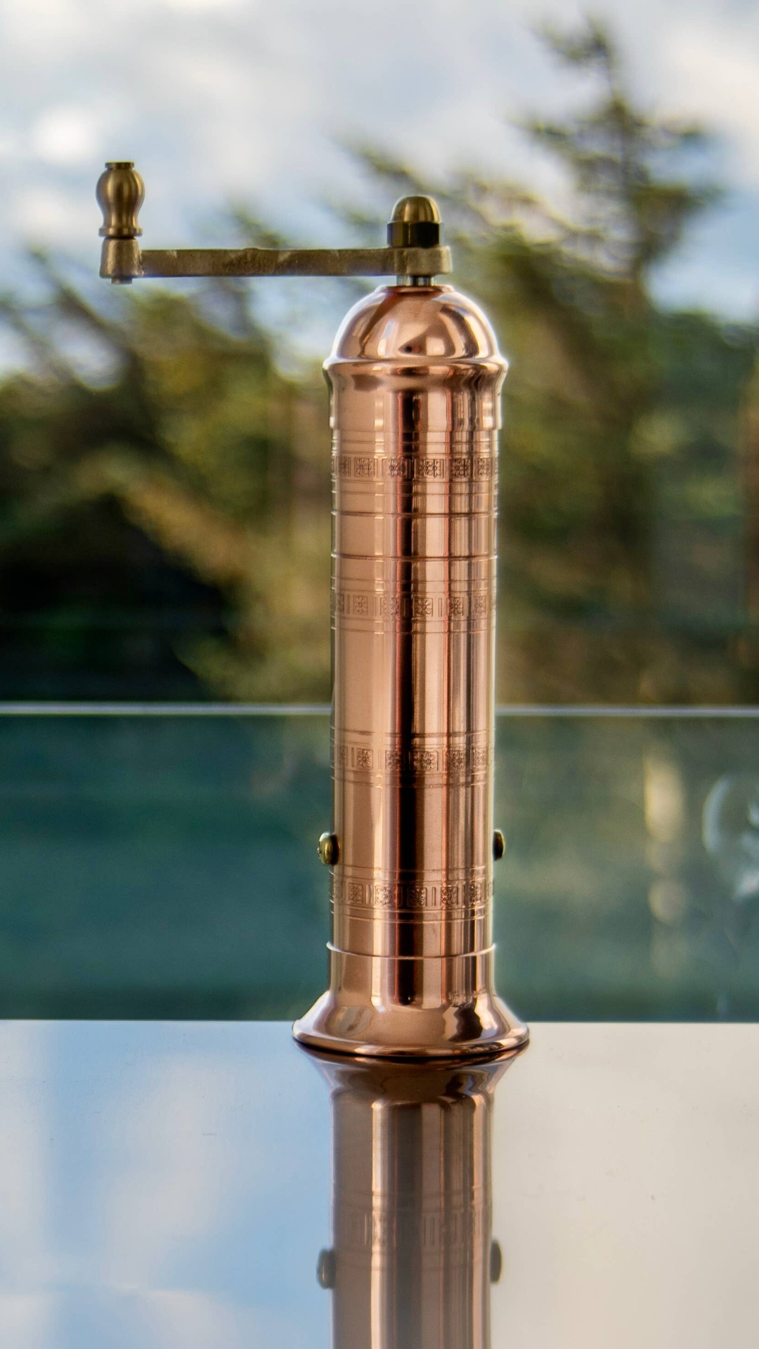 A solid copper 9-inch pepper mill from Alexander Handmade Mills, featuring a classic design with a powerful crank for optimal spice grinding.