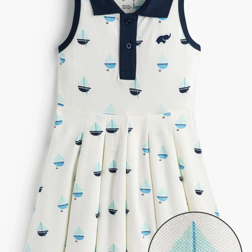 Flat lay of girls pleated tennis dress in Anchor Down navy with foldover collar and button placket