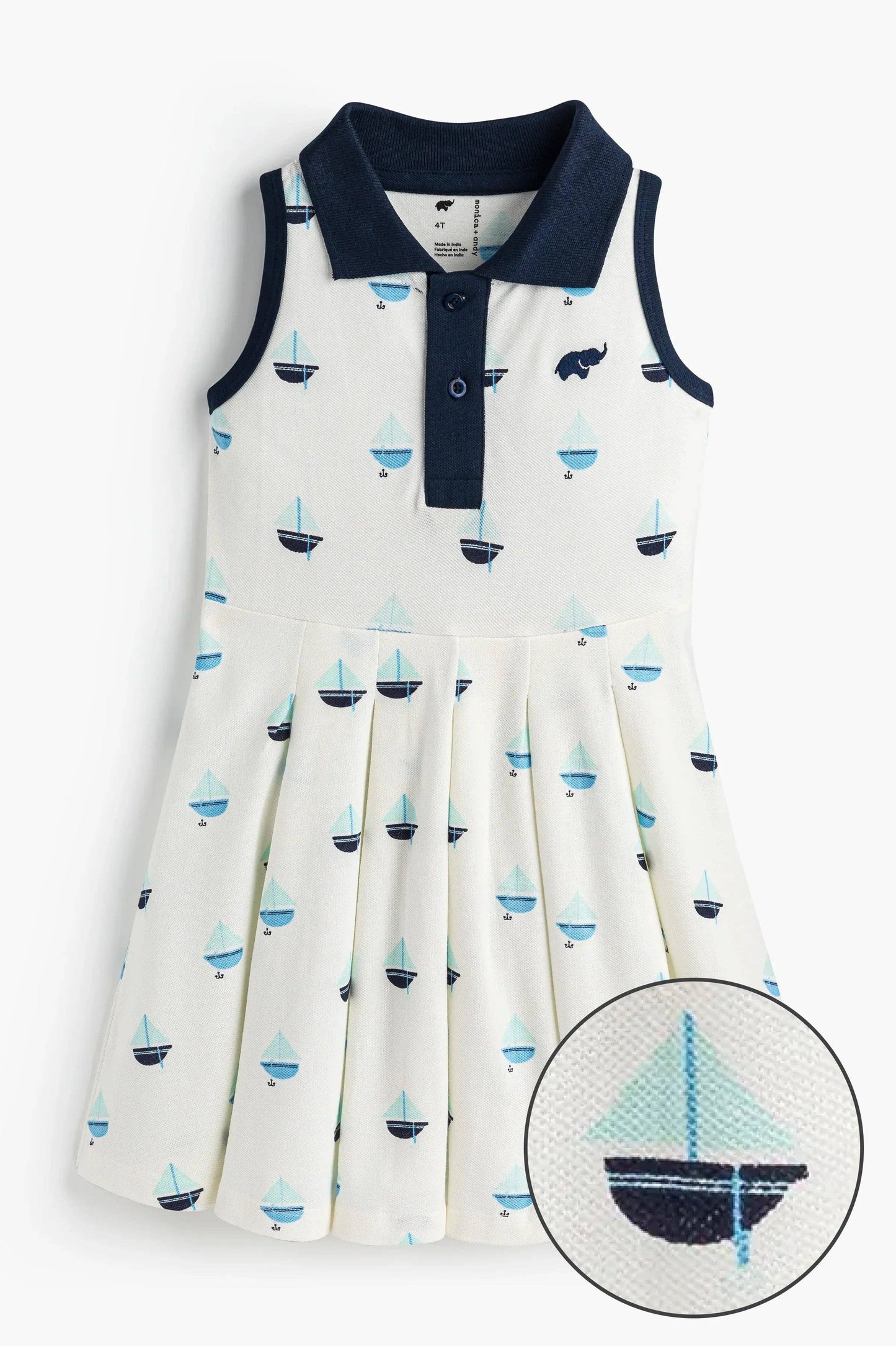Flat lay of girls pleated tennis dress in Anchor Down navy with foldover collar and button placket