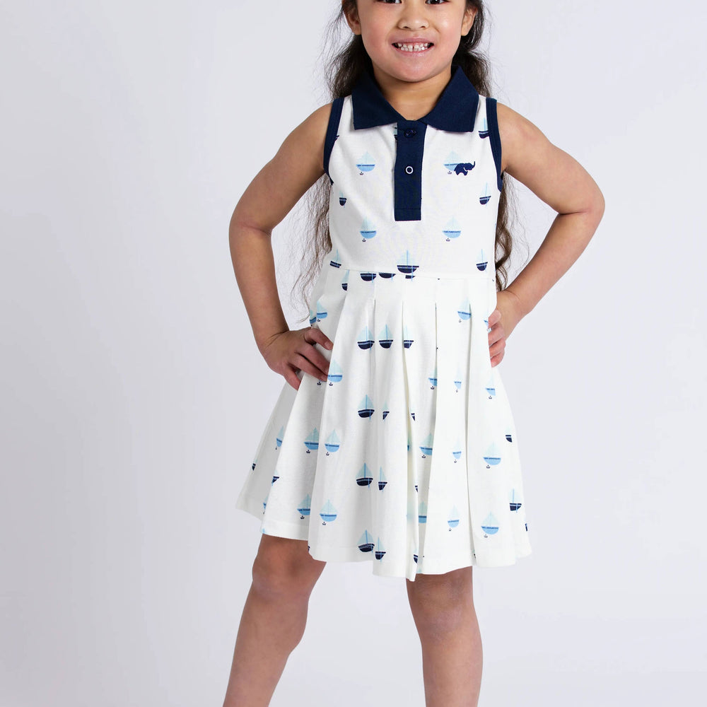 Girl wearing Anchor Down pleated tennis dress with hands on hips, showing classic silhouette and collar