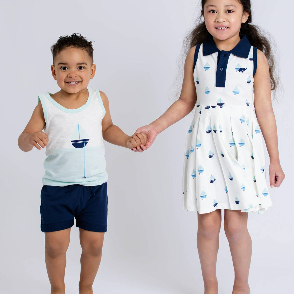
                      
                        Girl wearing Anchor Down pleated dress standing next to little brother in coordinating navy outfit
                      
                    