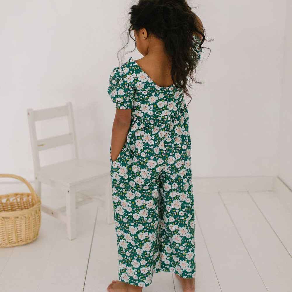Back view of toddler model wearing the puff sleeve romper, highlighting the relaxed fit and cropped wide-leg design.
