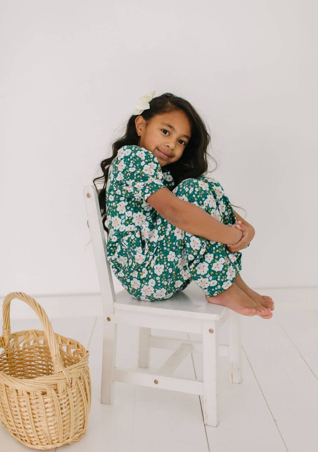 Toddler model sitting in the puff sleeve romper, showing the puffy sleeves and comfortable fit.