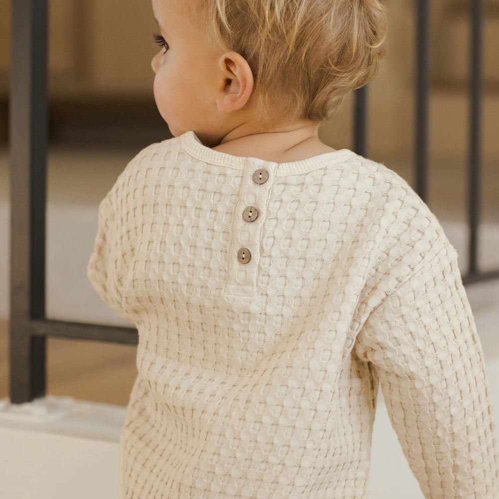 
                      
                        Close-up of Quincy Mae Flynn Set top, showing back button detail in natural chunky waffle knit fabric.
                      
                    