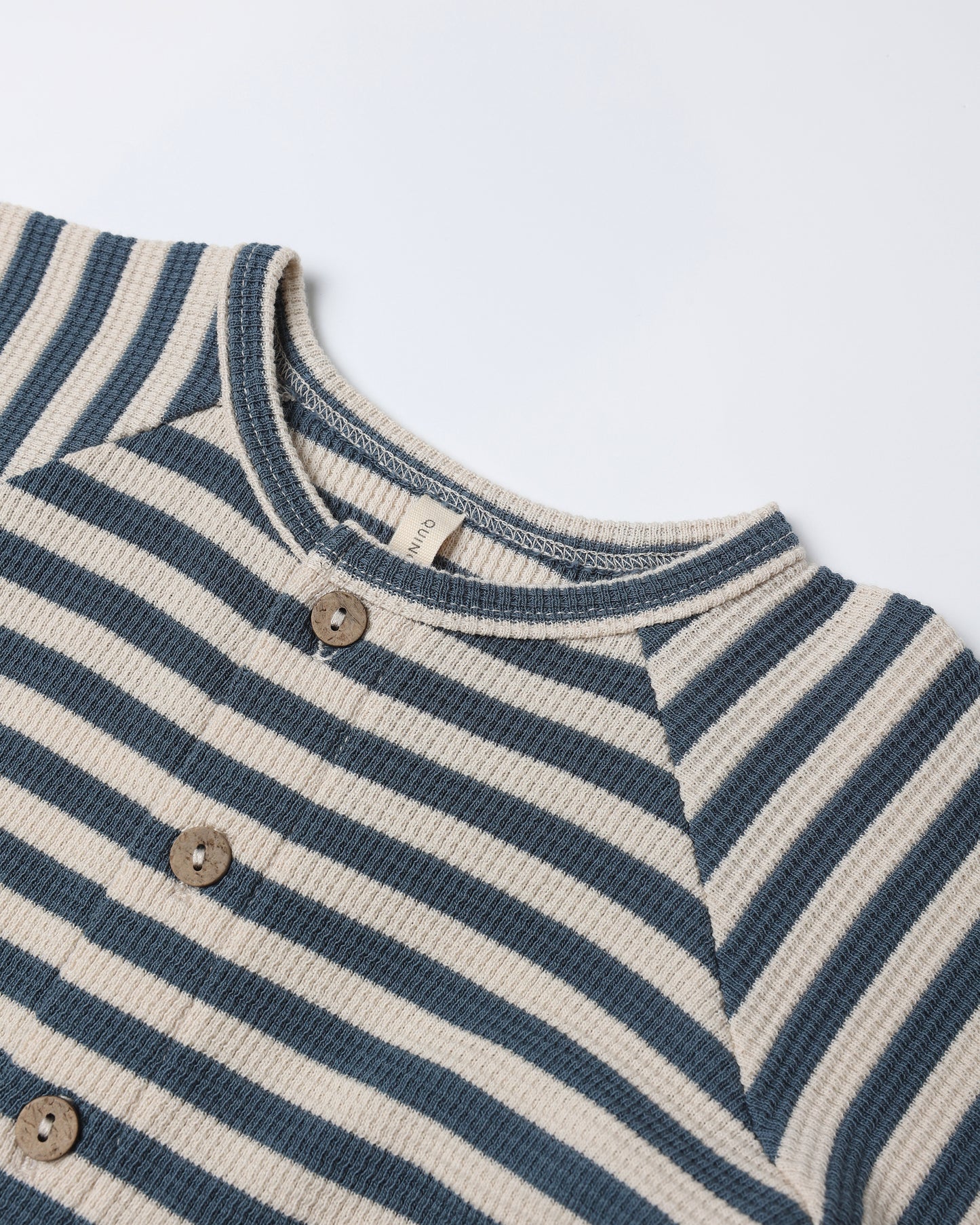 Close-up of ocean stripe pattern and waffle knit texture on Quincy Mae Waffle Long Sleeve Jumpsuit with hidden snaps.