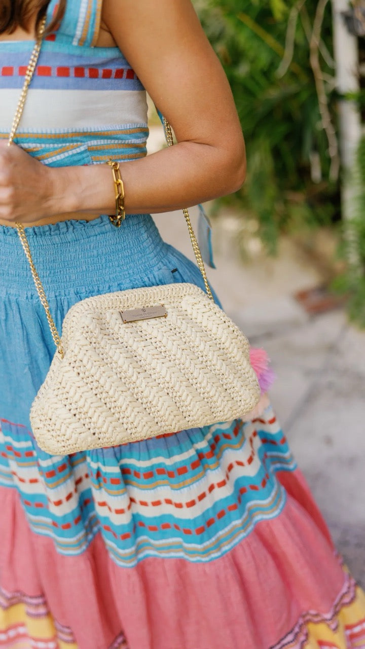 Side view highlighting the clutch's spacious interior and intricate weaving.