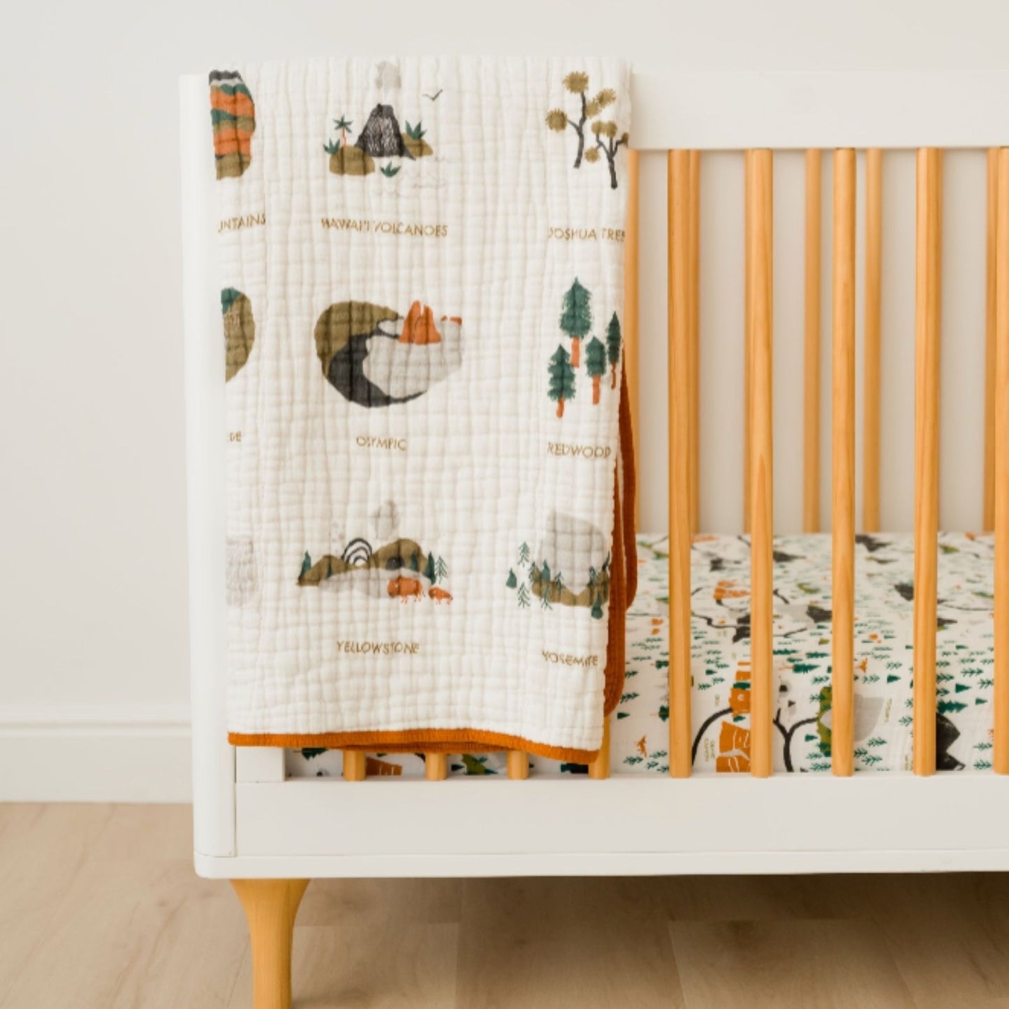 Baby on National Parks II Quilt in a bright nursery setting
