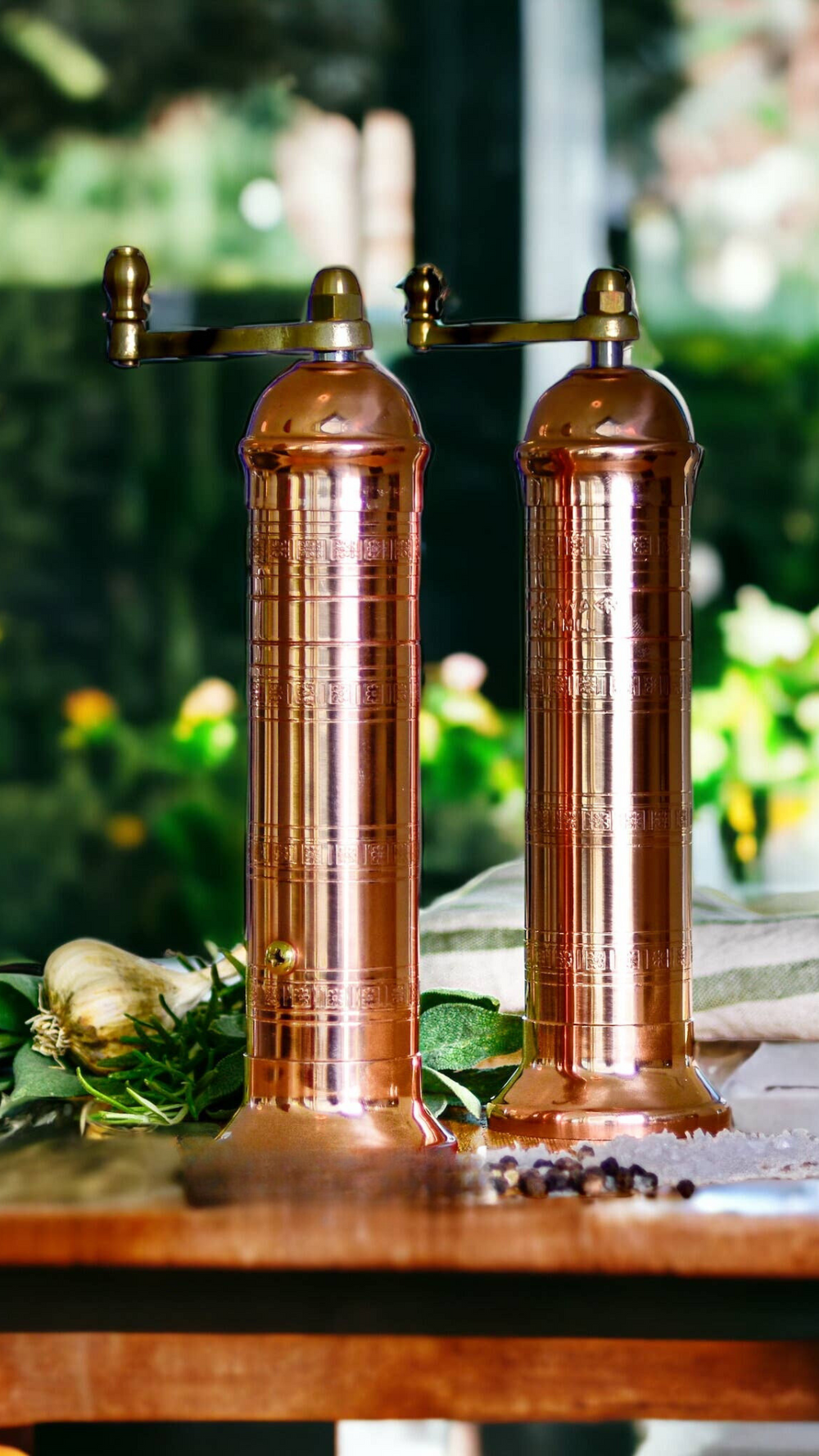 A matching salt and pepper mill set crafted from copper by Alexander Handmade Mills, showcasing timeless elegance and superior functionality.