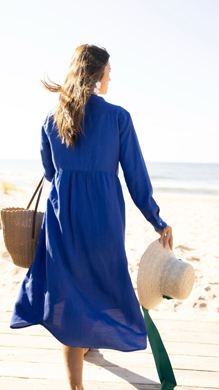 Back view of Savannah Dress in sapphire as model walks onto sandy beach – breathable linen Tencel blend