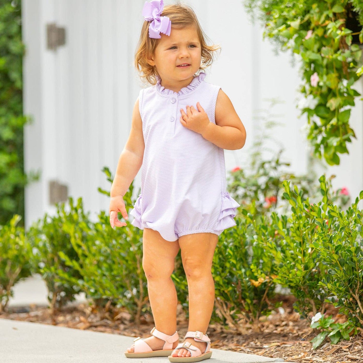 Outdoor photo of toddler wearing the St. Simons Stripe Ruffle Bubble by Serendipity, ideal for beach trips, summer holidays, and everyday play.