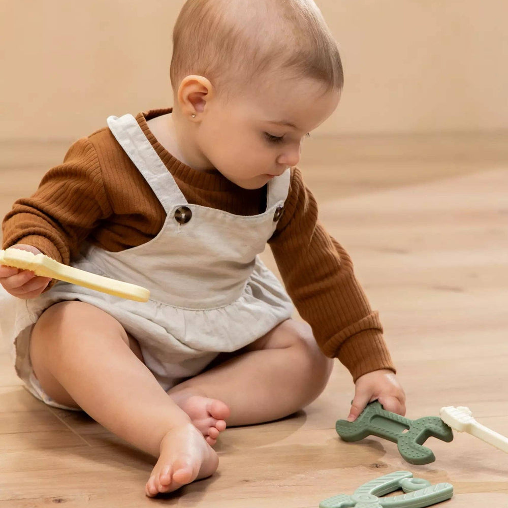 
                      
                        Baby hand gripping a soft silicone tool toy, illustrating the easy-to-hold size for infants and toddlers
                      
                    