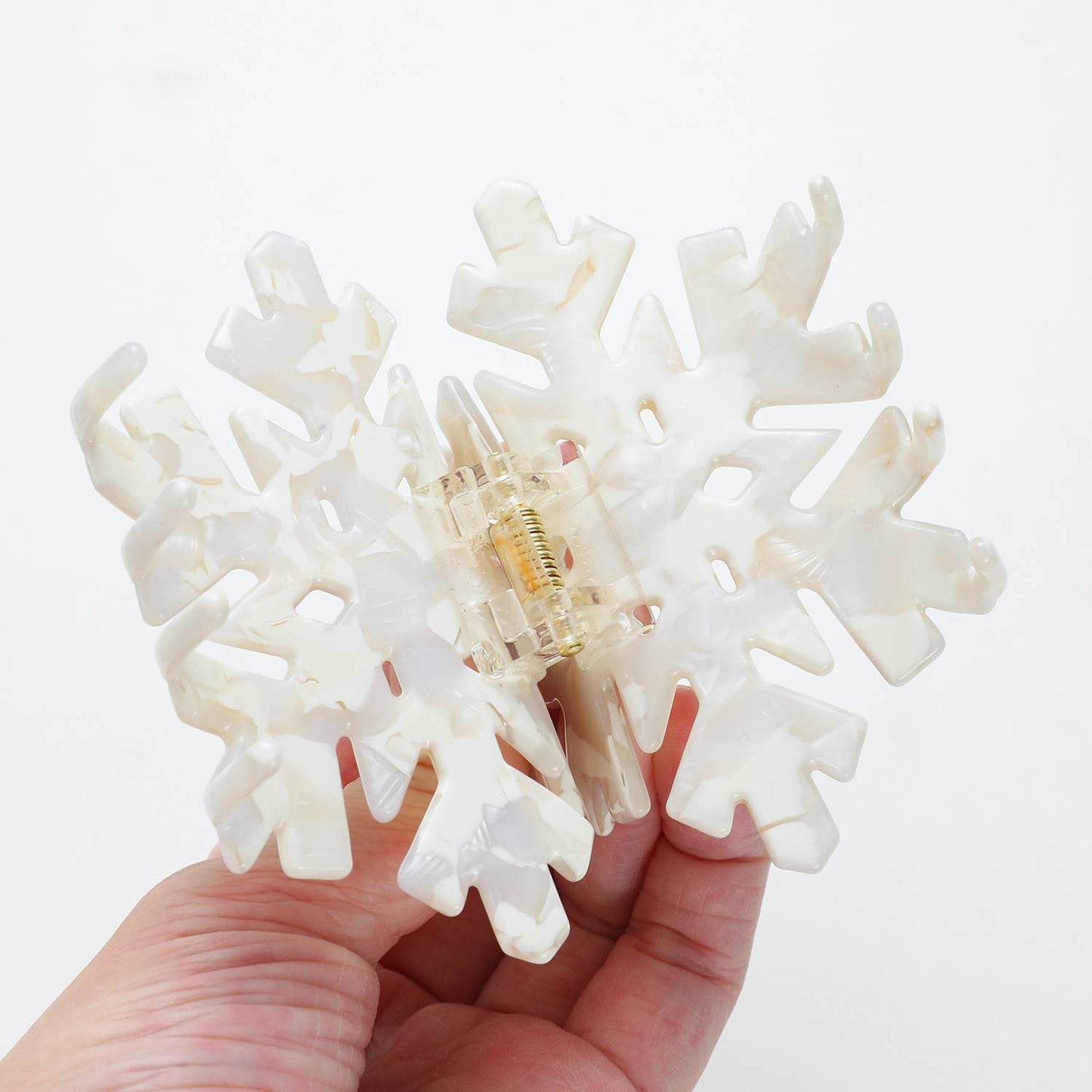 Snowflake Medium claw clip shown open demonstrating flexible teeth, secure hold, and durable cellulose acetate material