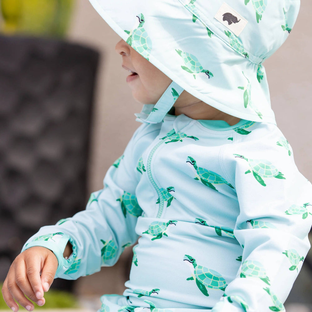 Side view of child wearing Sea Turtles UPF 50+ sun hat with chin strap, face not visible