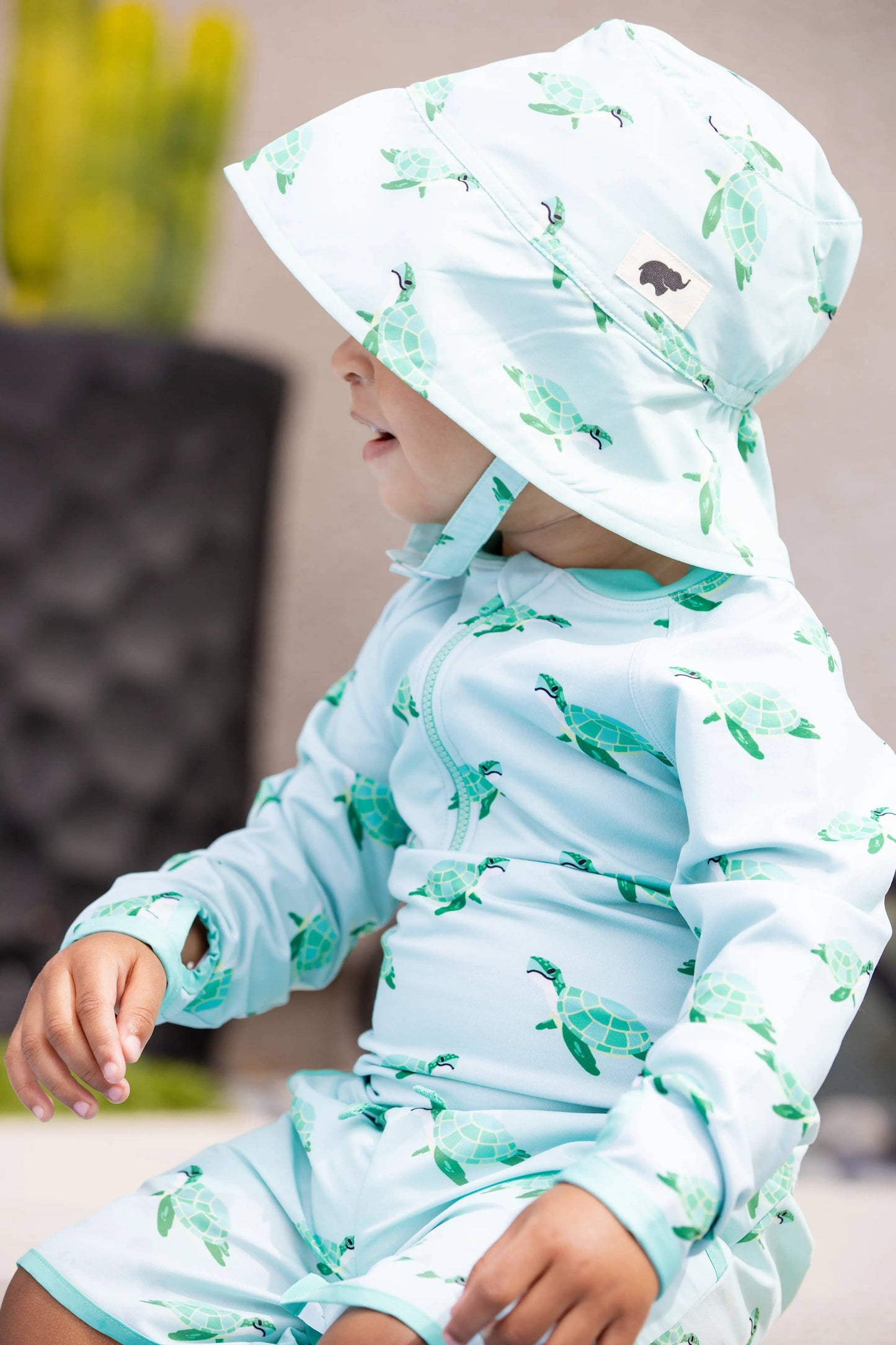 Side view of child wearing Sea Turtles UPF 50+ sun hat with chin strap, face not visible