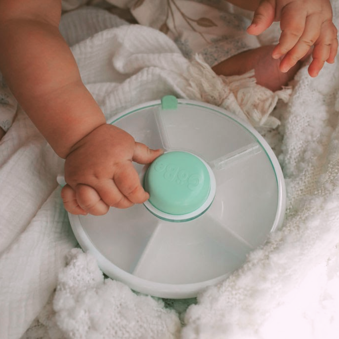 Baby pushing a travel-friendly 5-compartment snack spinner designed for kids, showcasing easy access to multiple snacks on the go.