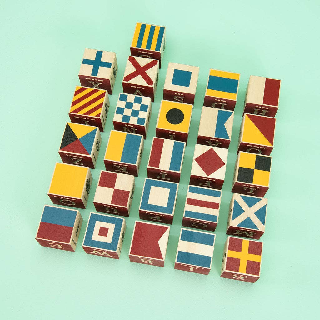 Flat lay of all wooden nautical alphabet blocks with letters and nautical images, perfect for educational play and stylish décor.